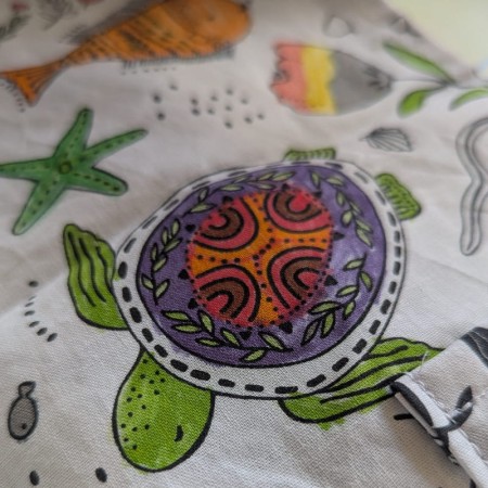 Coloriage lavable compact, variante "raies mantas", avec vue détail sur une tortue coloriée