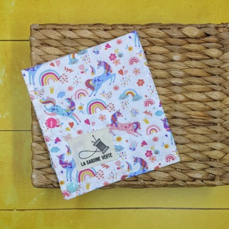Vue sur l'étiquette de la marque la sardine verte et sur le tissus licorne du coloriage lavable nomade