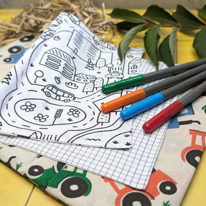 Page de coloriage représentant un rond point avec une voiture et des maisons dans le cahier d'activités lavable