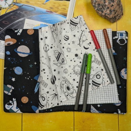 Page de coloriage représentant des fusées et des planètes dans le cahier d'activités lavable