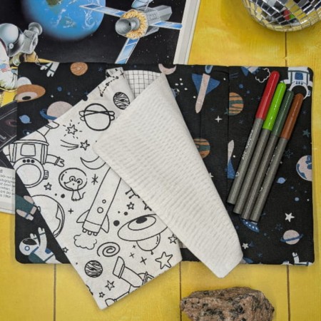 Page de dessin blanche et page de coloriage avec fusées dans le cahier d'activités lavable