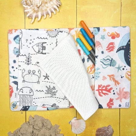 Vue sur un coloriage aux motifs d'animaux marins et d'une page blanche du cahier de coloriage lavable