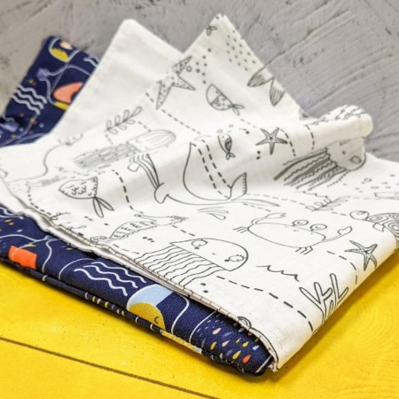 Focus sur un coloriage représentant des méduses et des crabes dans le cahier de coloriage lavable