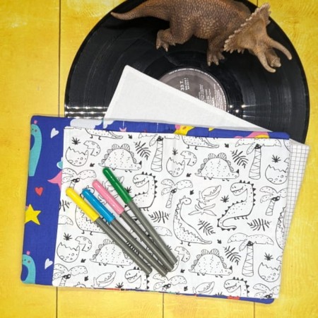 Une page de coloriage aux motifs de petits dinosaures dans le cahier de coloriage lavable violet