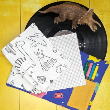 Un coloriage dinosaures et une page de pixel art dans le cahier de coloriage lavable violet