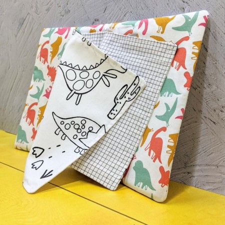 cahier de coloriage lavable dinosaures multicolor ouvert sur une page de coloriage avec des gros dinosaureset du pixel art