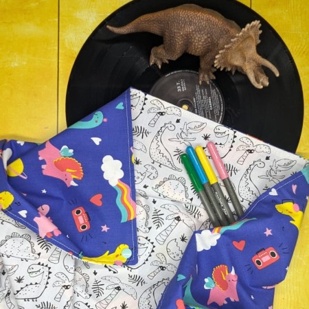 Tapis à colorier dinosaures déplié et feutres posés dessus