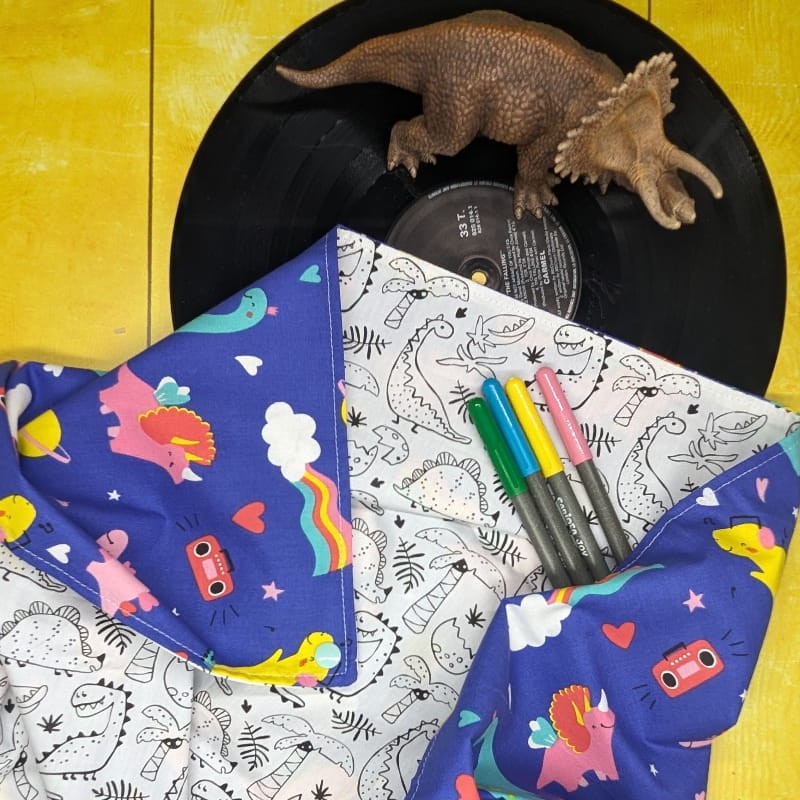 Tapis à colorier dinosaures déplié et feutres posés dessus