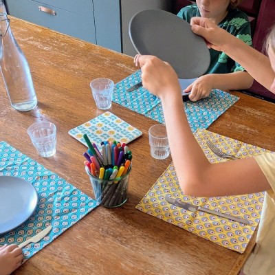 enfants qui mettent la table avec sets de table à colorier la sardine verte
